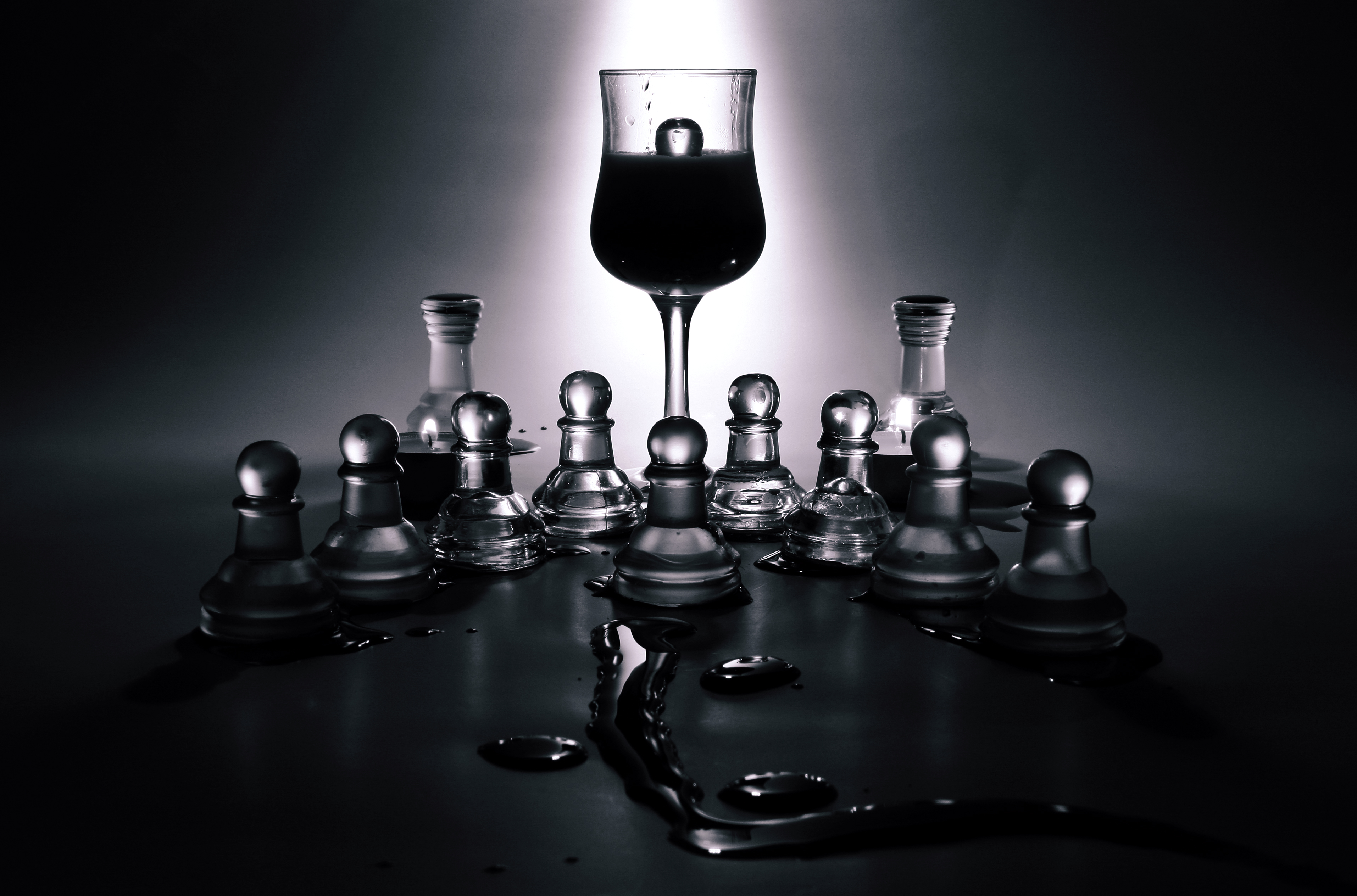 Clear and dark glass chess pieces arranged on a glass board, showing the contrast and reflections a gift buyer should inspect